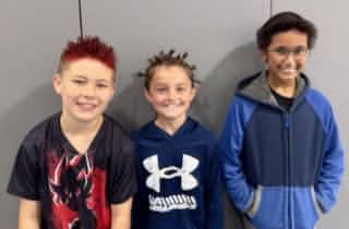 Three Mayflower students posing together indoors