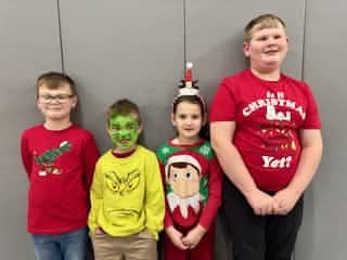 Four Mayflower students posing together in holiday clothing